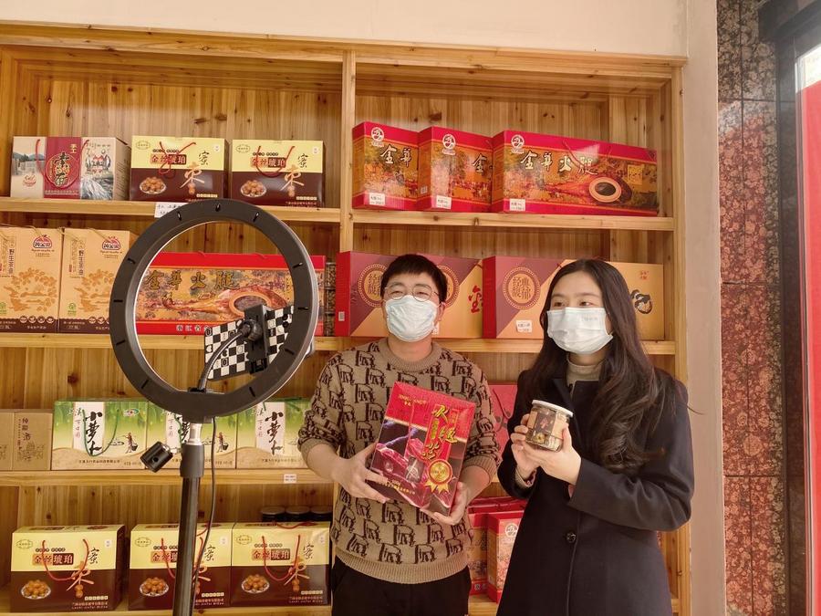图为兰溪市烟草专卖局工作人员（右）帮助零售户翁善斌（左）进行农产品直播带货